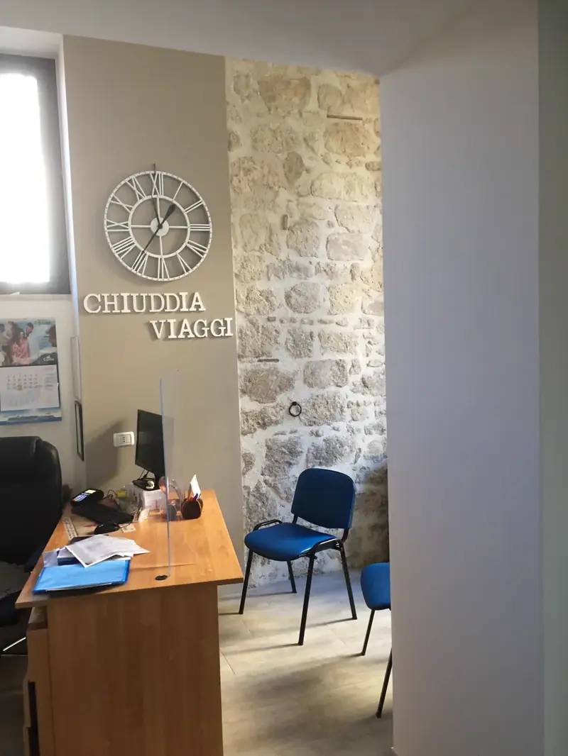 Il muro in pietra dell'agenzia Chiuddia Viaggi a Casteltermini con la scritta del nome
