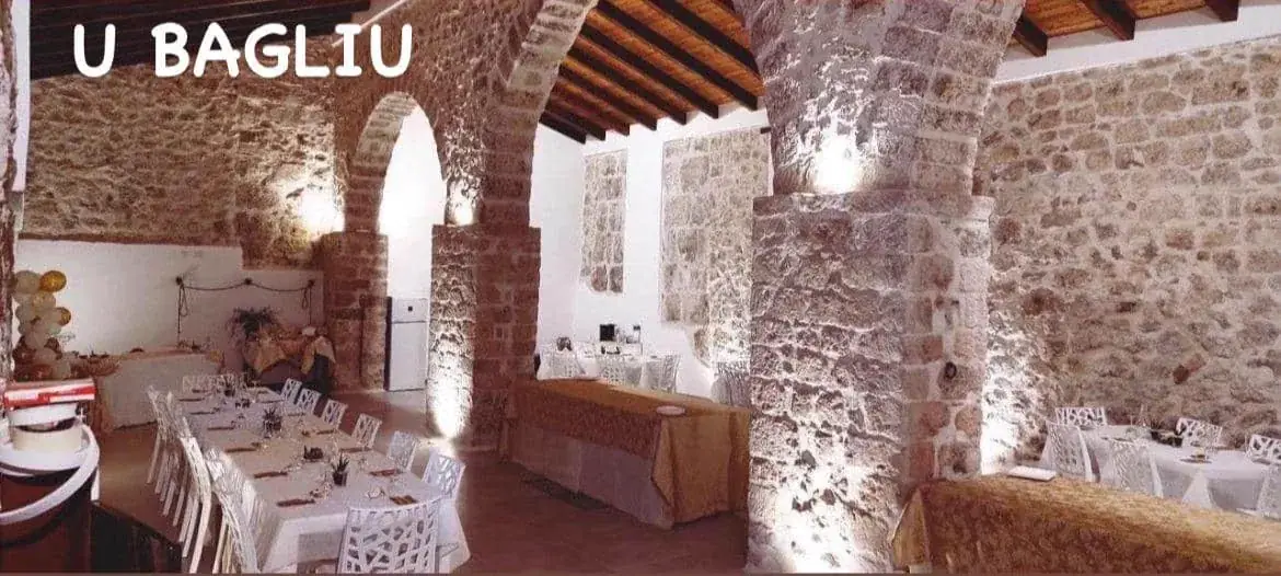 La sala U Bagliu con gli archi in pietra e i tavoli apparecchiati