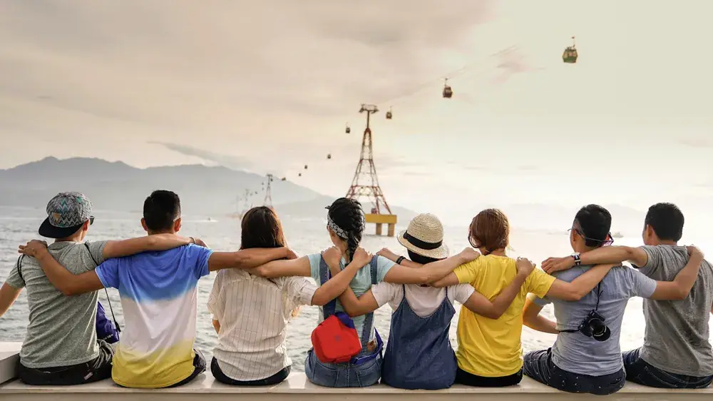 Un gruppo di amici abbracciati guarda il panorama